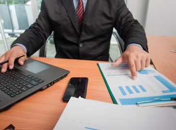 Professional reviewing multiple data records and reports illustrating identity resolution B2B challenges with fragmented accounts