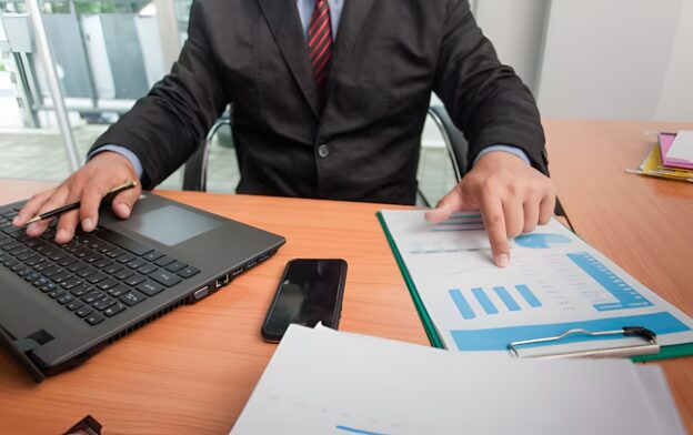 Professional reviewing multiple data records and reports illustrating identity resolution B2B challenges with fragmented accounts