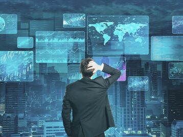 Business professional analyzing multiple dashboards and analytics screens to transform raw information into actionable data context for GTM intelligence