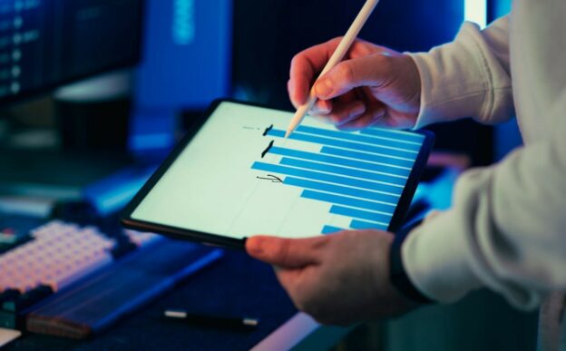 Professional analyzing visual analytics on a tablet as part of a B2B data interpretation framework for business decision-making