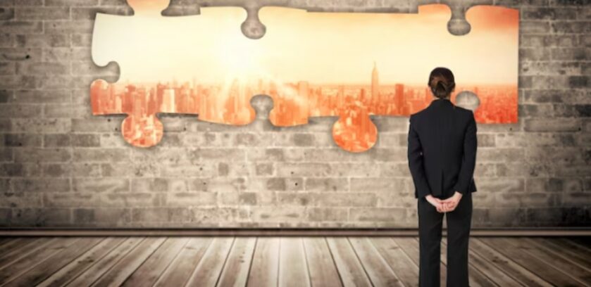 Business professional looking at interlocking puzzle pieces symbolizing M&A data integration and the challenge of aligning systems, data, and RevOps after a merger.