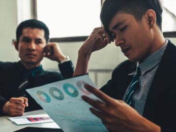 Business professionals reviewing complex performance reports, highlighting how distributed intelligence RevOps can reduce analytics bottlenecks and accelerate GTM decisions.