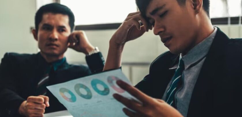 Business professionals reviewing complex performance reports, highlighting how distributed intelligence RevOps can reduce analytics bottlenecks and accelerate GTM decisions.
